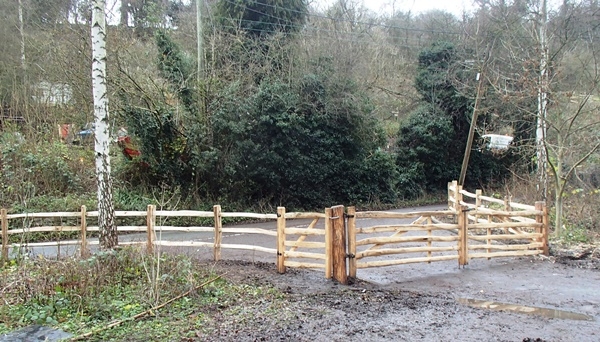A pair of cleft Chestnut Mordiford gates with post and rail fencing A pair of rustic cleft Chestnut Mordiford gates with post and rail fencing