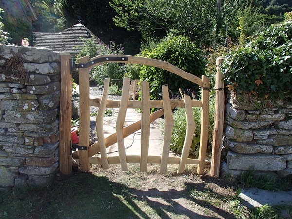 Cleft Chestnut gate with bent top rail and blacksmith forged furniture Cleft Chestnut gate with bent top rail and blacksmith forged furniture